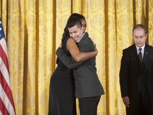 Jefry Amaya, beneficiario del proyecto OYE, se abraza con la primera dama Michelle Obama.