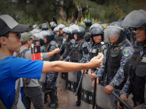 Los policias ofrecen palos golpes y gas lacrimogeno mientras los estudiantes los reciben con flores